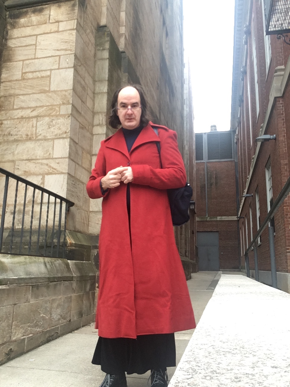 Wearing a maxi black skirt and a long red coat.